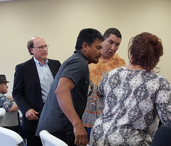 Tomasini (left) stopping Gutierrez (in orange) from arresting woman for speaking out